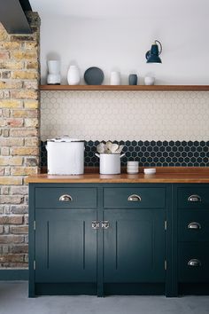 an image of a kitchen setting with blue cabinets and white dishes on the counter top