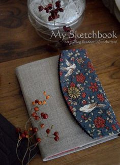 two pieces of cloth are sitting next to each other on a wooden table with flowers