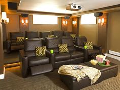 a home theater with brown leather seats and pillows