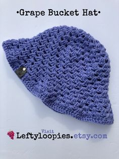 a crocheted beanie hat with a button on the side that says grape bucket hat