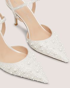 a pair of women's shoes with pearls on the toes and heels, all in white