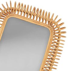 a mirror that is made out of wood and has spikes on the edge of it