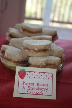 small sandwiches are sitting on a table with a sign that says peanut butter and strawberry sandwich