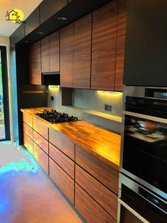 a modern kitchen with wooden cabinets and stainless steel stove top, oven and microwave combination