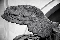 a statue of an angel with wings on it's back and head is shown in black and white