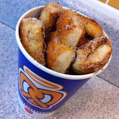 a blue cup filled with sugar covered donuts