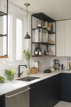 a kitchen with black and white cabinets, stainless steel sink and dishwasher in it