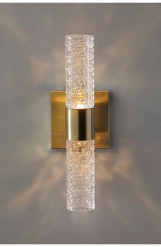 a wall light that is gold and has two lights on each side of the lamp