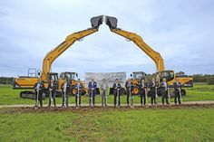 a group of men standing next to each other in front of construction equipment