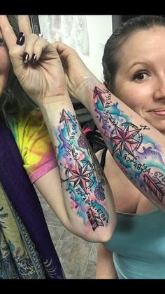 two women with colorful tattoos on their arms