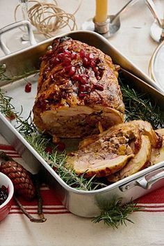 a turkey with cranberry sauce in a roasting pan on a red and white tablecloth