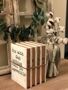 three books sitting on top of a table next to a vase with flowers in it