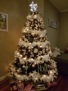 a decorated christmas tree with white and silver ornaments