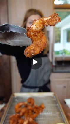 a woman is holding up some fried food