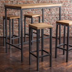 four stools and a table in front of a brick wall with wood flooring