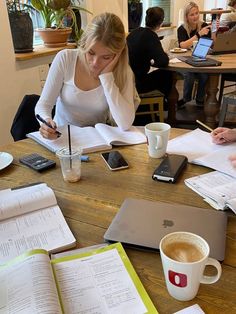 two women sitting at a table with notebooks and papers