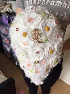 a bridal bouquet made out of feathers and jewels is displayed in front of a woman's face