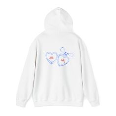 a white hoodie with two hearts drawn on the front and blue writing on the back