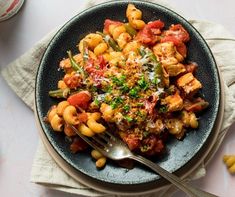 a bowl filled with pasta and vegetables on top of a table