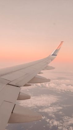 the wing of an airplane is seen above the clouds