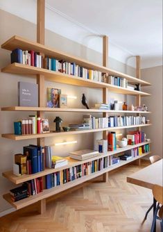 a bookshelf filled with lots of books on top of wooden shelves in a room