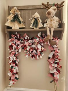 two stuffed animals are sitting on a shelf decorated with ribbon garlands and bow ties