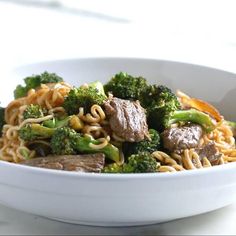 a white bowl filled with beef and broccoli