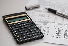 a calculator sitting on top of some papers