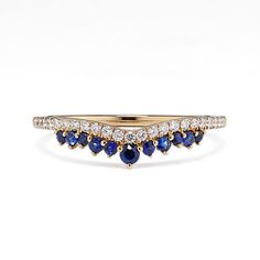 a yellow gold ring with blue sapphires and diamonds on the sides, set in 18k white gold