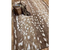 a brown and white area rug with an animal print on the floor next to it