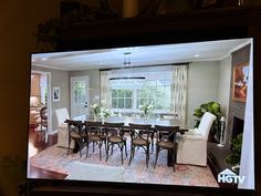 a large flat screen tv showing a dining room and living room in the same house