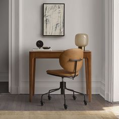 an office chair sits in front of a desk with a lamp on top of it