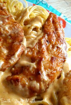 some meat and noodles on a plate with gravy