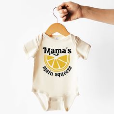 "A Baby Bodysuit that says \"Mama's Main Squeeze\" with a picture of a lemon centered on the bodysuit. Sizes range from 0-3 months in US kid's numeric all the way up to 12-18 months. Made of 100% cotton. Proudly made in the USA" Main Squeeze Baby Shower Theme, Main Squeeze, How To Squeeze Lemons, Baby Shower Theme, Welcome Baby, All The Way Up, Vinyl Designs, Unisex Baby, Heat Press