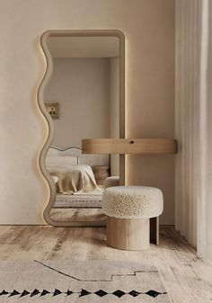 a large mirror sitting on top of a wooden floor next to a white chair and ottoman