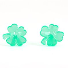 two green flower shaped glass studs on a white background with clipping to the side