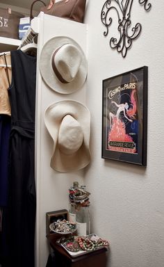 hats are hanging on the wall next to clothes