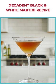 a martini glass filled with liquid on top of a white counter next to an oven