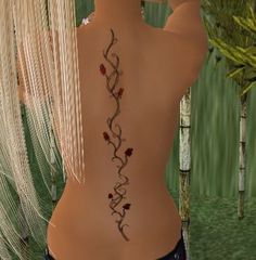 the back of a woman's body with tattoos on her left side and flowers in the middle