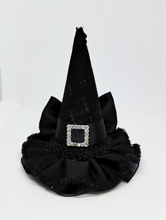 Miniature witch hat for babies, girls, adults and pets. Mini hat size is approximately 3.5 inches wide by 4 inches tall. Mini hat can be attached to a metal alligator clip, a soft elastic headband, or ribbon for pets. Please choose the finish: -2.6 inches alligator clip  -5/8 by 16 or 18 inches soft elastic headband  -3/8 by 18 or 25 inches ribbon (for pets) Finish color: -Metal Clip -Black  -Gray  -There may be slight variation in size  -Due to lighting color may vary slightly  -Miniature hats Novelty Brimmed Mini Hats For Costume, Novelty Brimmed Mini Hat For Costumes, Halloween Costume Hat Accessories, Handmade Halloween Costume Accessories, Novelty Brimmed Mini Hats For Halloween, Adjustable Wide Brim Witchy Mini Hats, Witchy Adjustable Wide Brim Mini Hats, Witchy Wide Brim Adjustable Mini Hats, Novelty Halloween Costume Hats And Headpieces As Gifts