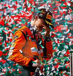 a man in an orange jacket is surrounded by confetti