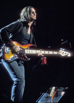 the man is playing his guitar on stage