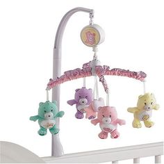 a baby crib with teddy bears hanging from it