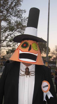 a man in a suit and hat with a spider on his face