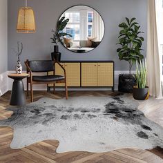 a living room with grey walls and wooden flooring has a round mirror on the wall