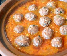 some meatballs are sitting in a red sauce