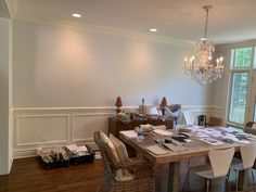 a dining room table with chairs and a chandelier hanging from it's ceiling