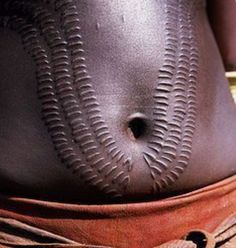 a woman's belly with an intricate design on the top and bottom, in brown leather