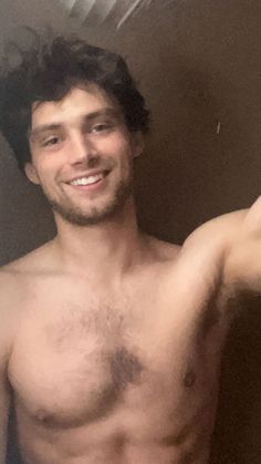 a shirtless man is taking a selfie in the mirror