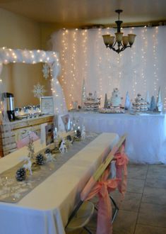 a table set up for a party with white and pink decorations